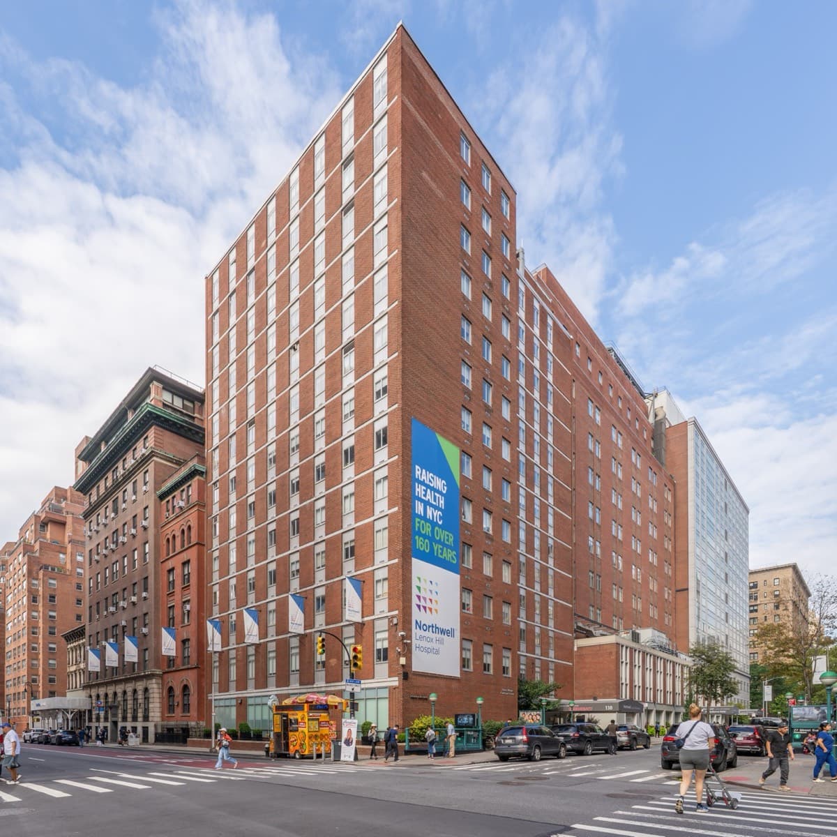 The red-brick tower of Lenox Hill Hospital on a Manhattan street corner.