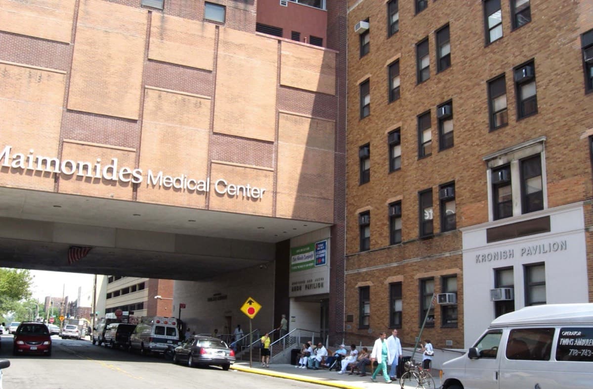 The street entrance of Maimonides Medical Center beneath its name on a sandstone facade.