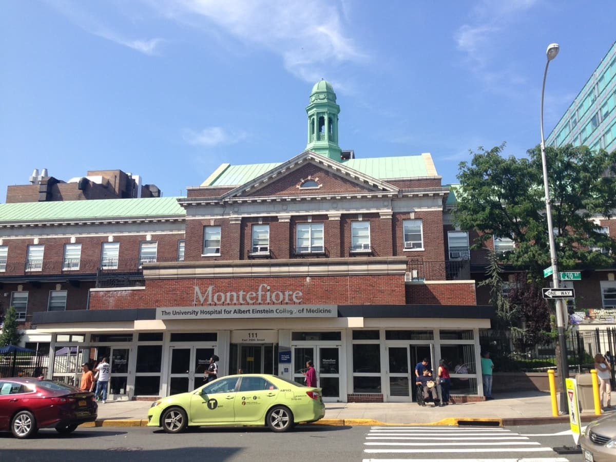 The brick entrance building of Montefiore Medical Center, topped by a green cupola.