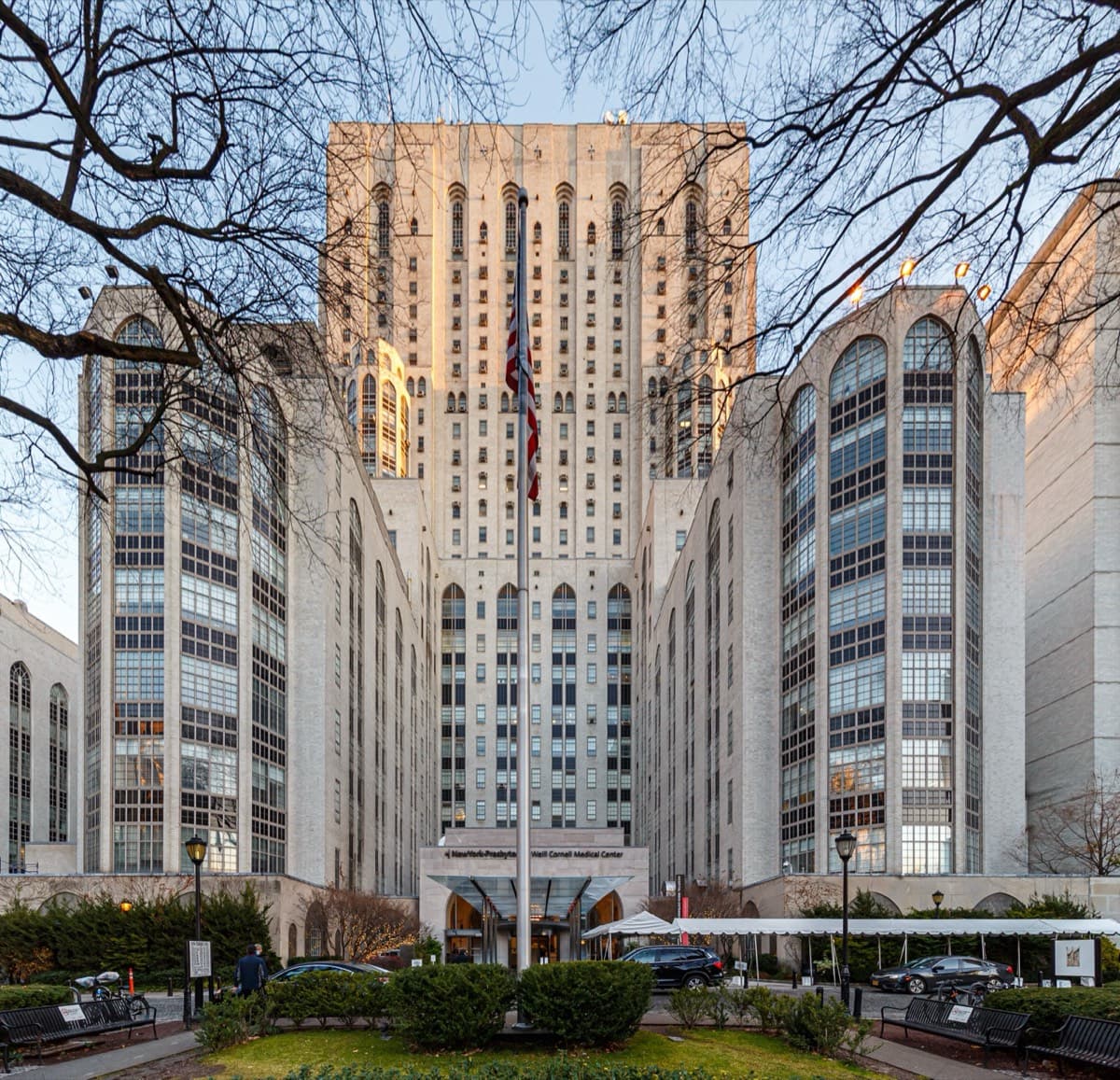 The pale stone towers of NewYork-Presbyterian / Weill Cornell Medical Center behind a tree-lined forecourt.